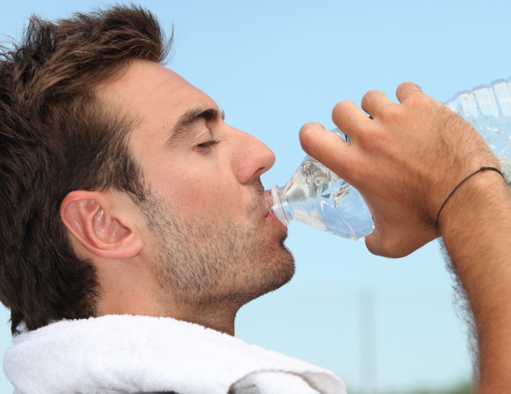 thirsty-man-drinking-water-during-training-in-park-free-stock-photo